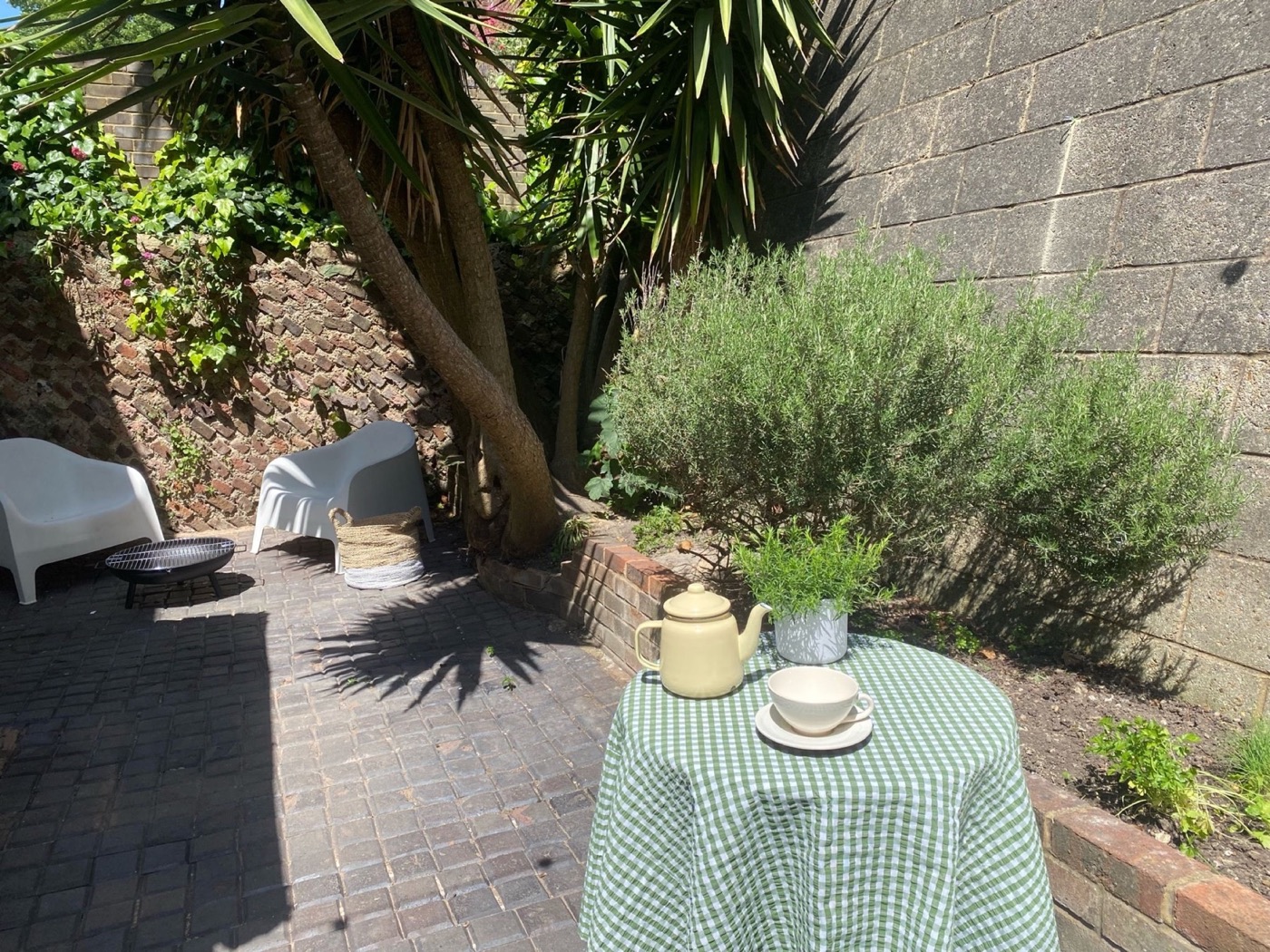Tea laid out at the courtyard table beneath the trees