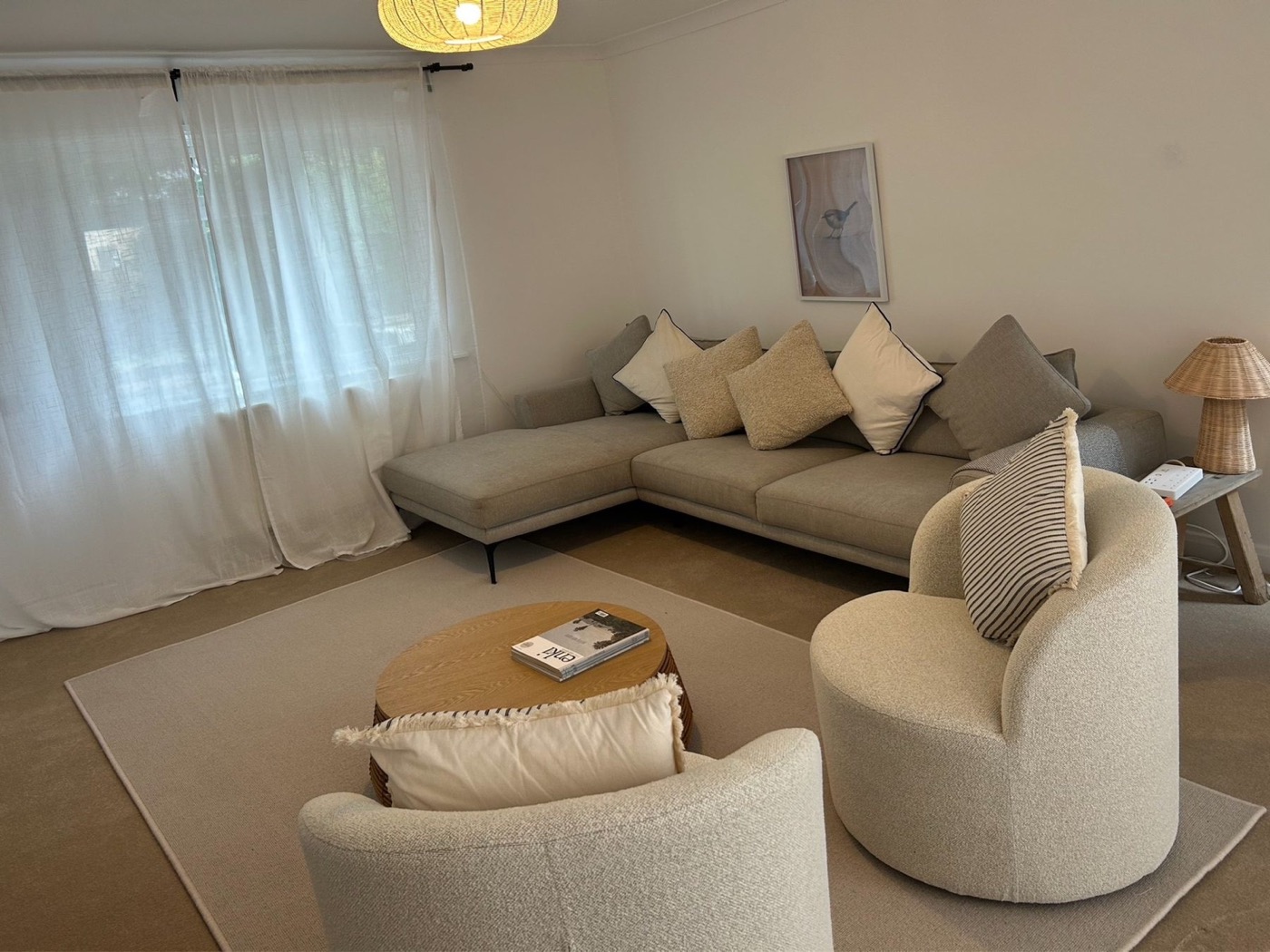 Warm neutral living room with generous corner sofa and armchairs